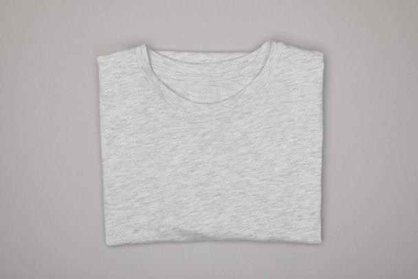 top view of blank basic grey t-shirt isolated on grey - Foto, afbeelding