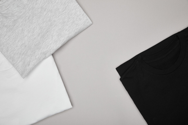 vista superior de las camisetas básicas en blanco, negro, blanco y gris aisladas en gris
 - Foto, Imagen