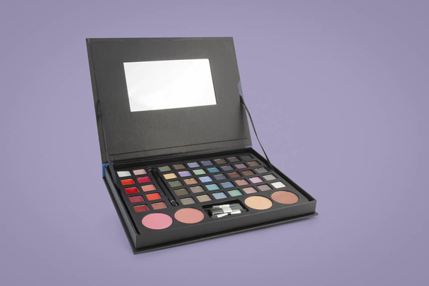 Cosmetica: Een make-up palet geval over kleurrijke achtergrond - Foto, afbeelding