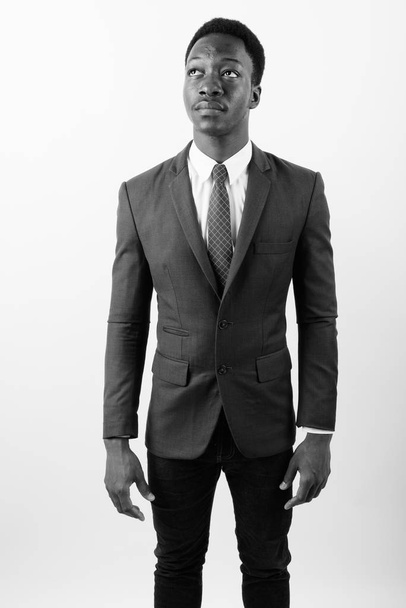 Young handsome African businessman wearing suit against white background - Foto, afbeelding