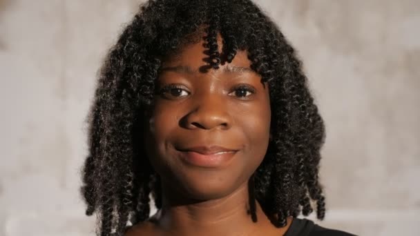 Menina afro-americana com cabelo encaracolado olha para frente e sorri
 - Filmagem, Vídeo