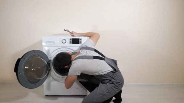 réparateur machine à laver cassée près mur beige
 - Séquence, vidéo