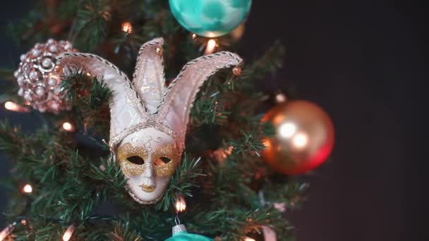 Sluiten van een masker op een kerstboom op een feest. - Video