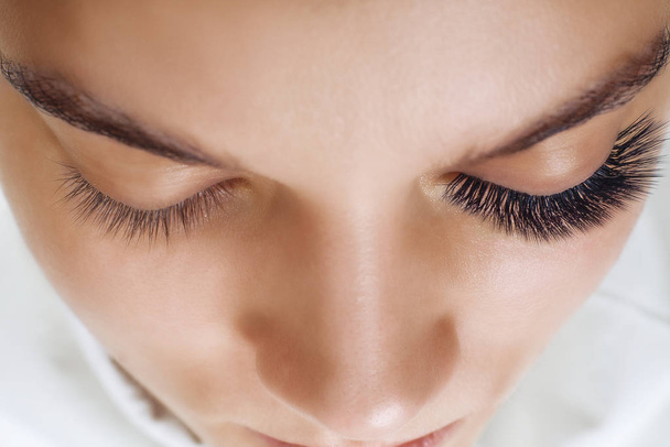 Eyelash Extension Procedure. Woman Eye with Long Blue Eyelashes. Ombre effect. Close up, selective focus. - Photo, Image