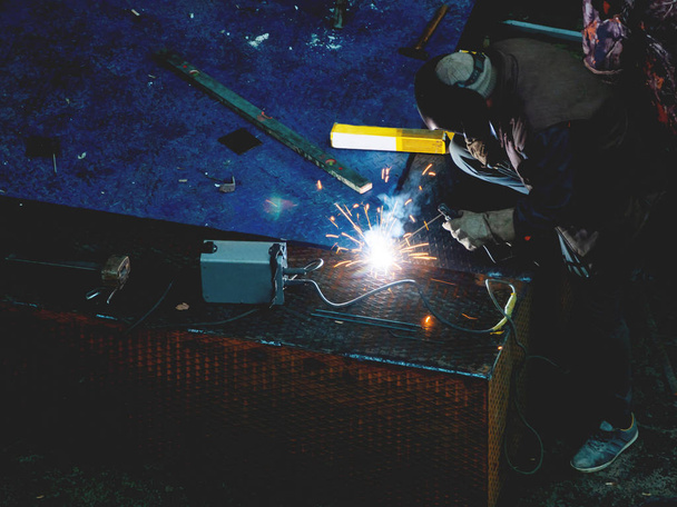 Metalen lassen. Werknemer in een lasmasker repareert metalen treden. - Foto, afbeelding