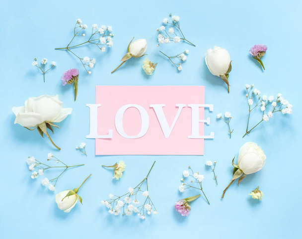 Flowers and word LOVE on a light blue background - Φωτογραφία, εικόνα
