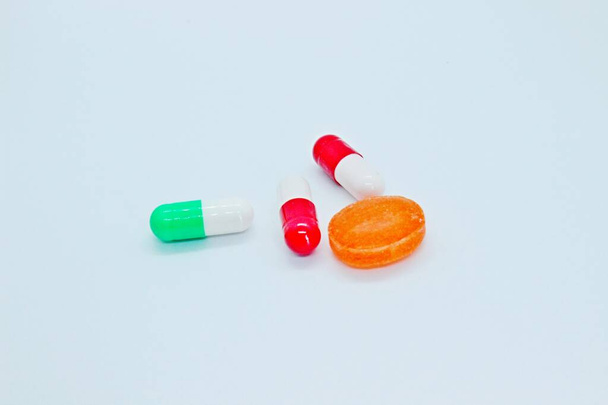 Multi-colored pills are located on a white background - Fotoğraf, Görsel