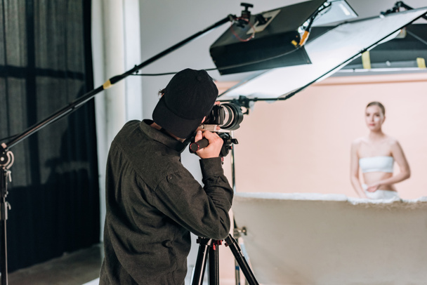 Selective focus of cameraman working with beautiful model in photo studio - Φωτογραφία, εικόνα