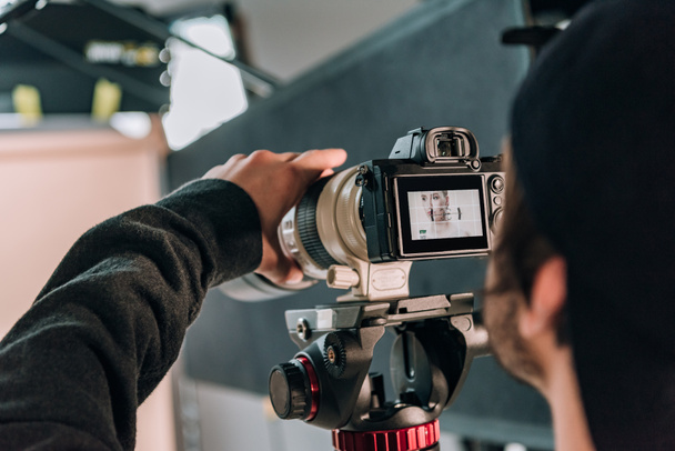 Selective focus of videographer filming woman in photo studio - Foto, Imagem