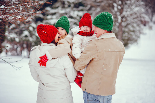 Family with cute daughters in a winter park - Foto, Imagen