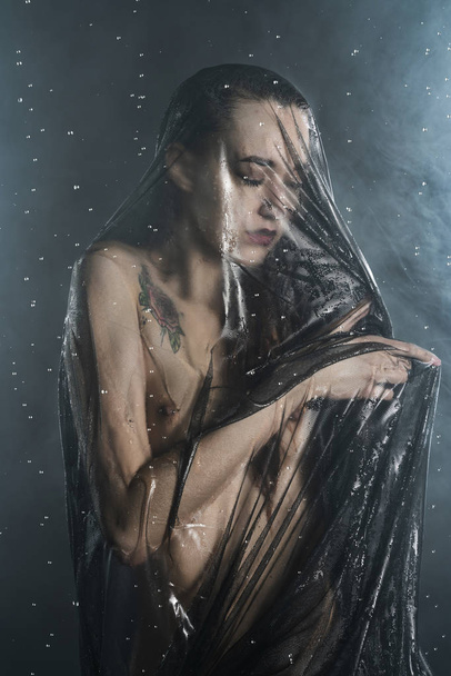 Beautiful slim wet girl, sensually posing nude in the rain, in t - 写真・画像
