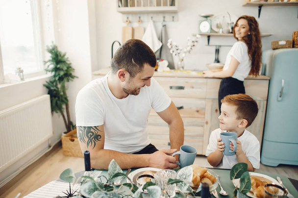 Loving family sitting in a kitchen at home - Fotografie, Obrázek