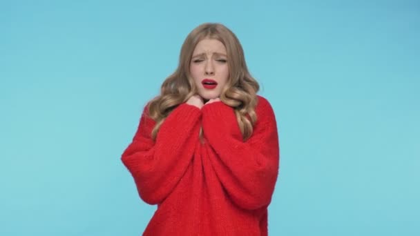 Shocked pretty woman in sweater having scared and showing stop gesture with hands over turquoise background - Video