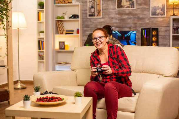 Femme gamer jouant à des jeux vidéo sur la console dans le salon
 - Photo, image