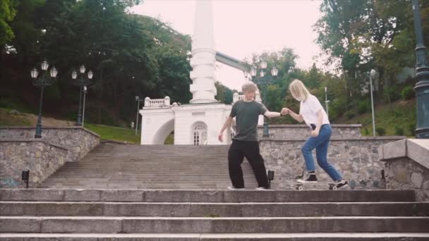 The guy is teaching his girlfriend to skateboard. Date of hipsters. - Footage, Video