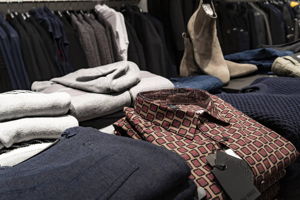 Κατάστημα ρούχων. Πουκάμισο και πουλόβερ για πώληση εμφανίζεται σε ένα ράφι κατάστημα - Φωτογραφία, εικόνα