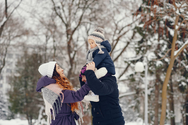 Little girl with parents in a winter park - Foto, afbeelding