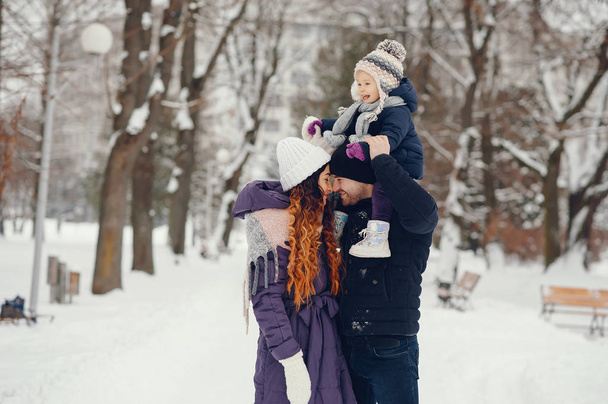 Little girl with parents in a winter park - Foto, imagen