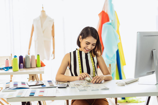 Porträt junge asiatische Designerin, die am Arbeitsplatz arbeitet und Geld zählt, Kleinunternehmerin, Unternehmerin, Investition und Gewinn, freiberufliche Lebensstilkonzepte.asean people - Foto, Bild