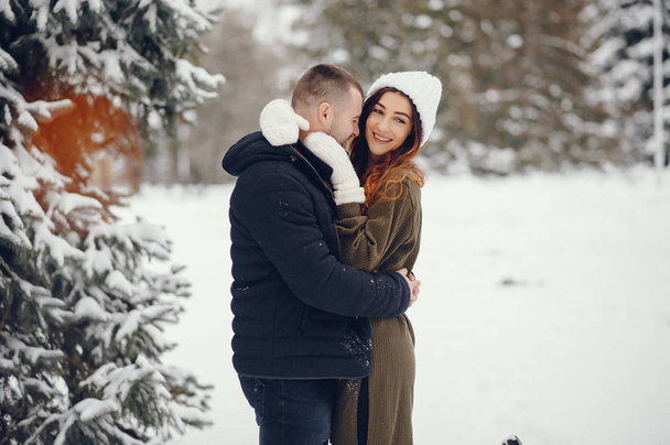 Beutiful woman in a winter park with her husband - Фото, изображение