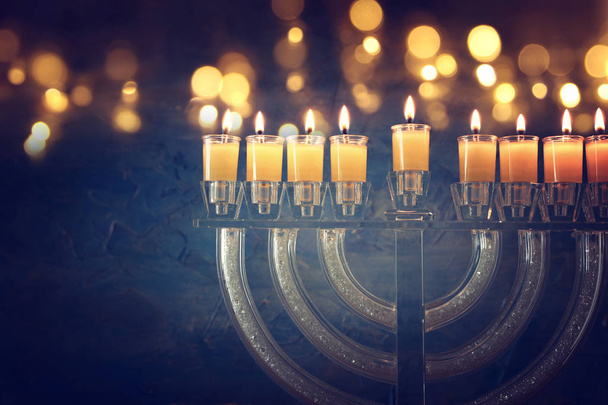 image of jewish holiday Hanukkah background with crystal menorah (traditional candelabra) and colorful oil candles - Fotografie, Obrázek