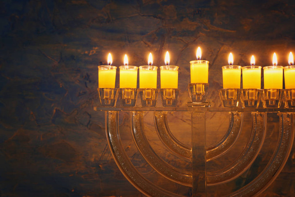 image of jewish holiday Hanukkah background with crystal menorah (traditional candelabra) and colorful oil candles - Фото, зображення