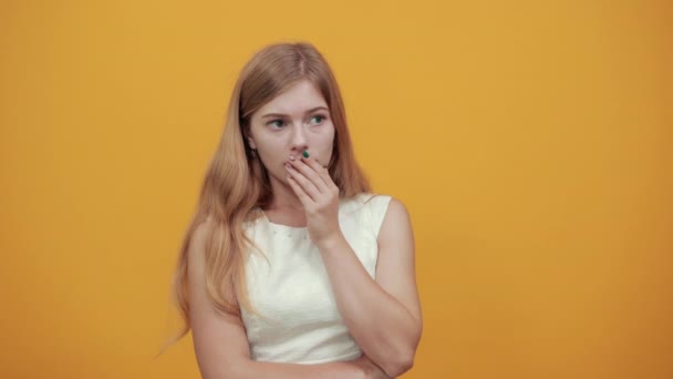 Mujer atractiva cubriendo la boca con la mano, sosteniendo la mano en la cabeza mirando asustado
 - Metraje, vídeo
