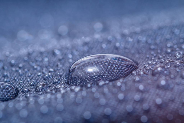 Close-up προβολή σε νερό σταγόνα σε αδιάβροχο εμποτισμένο ύφασμα. - Φωτογραφία, εικόνα