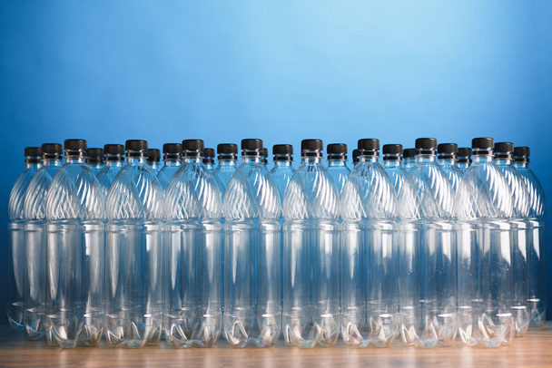 пустые пластиковые бутылки на синем фоне
 - Фото, изображение