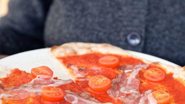 деталь італійської піци в ресторані з помідорами
  - Фото, зображення