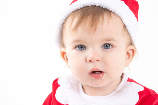 Studio photo with a white background of the portrait of a baby dressed as Santa Claus - Fotó, kép