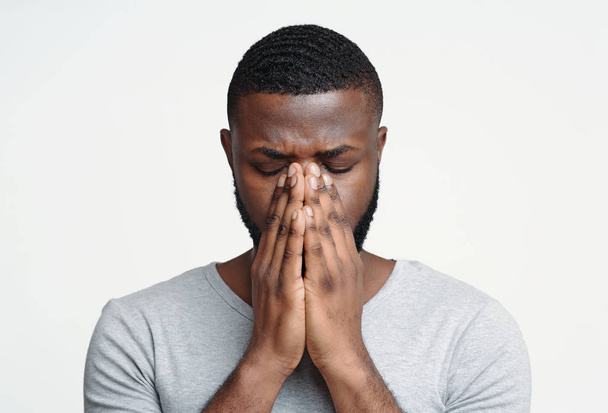 Triste homme noir tenant son nez parce que douleur sinusale
 - Photo, image