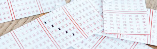 İşaretli loto biletlerinin ahşap masada panoramik çekimi - Fotoğraf, Görsel