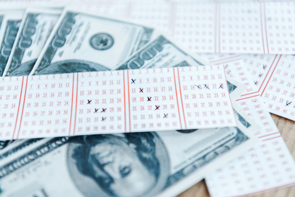 επιλεκτική εστίαση των σημειωμένων λαχειοφόρων αγορών κοντά σε χαρτονομίσματα του δολαρίου στο τραπέζι - Φωτογραφία, εικόνα