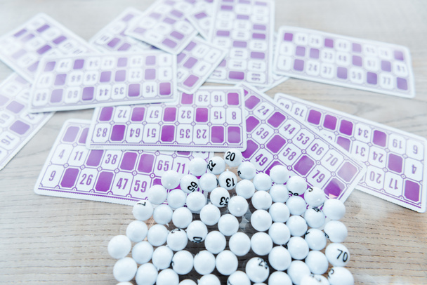 selective focus of balls with numbers in glass near lottery tickers  - Photo, Image