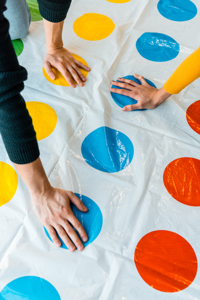 KYIV, UKRAINE - NOVEMBER 22, 2019: cropped view of man and woman playing twister game  - 写真・画像