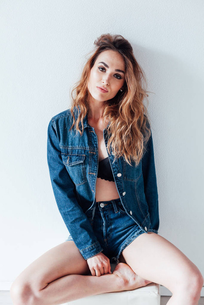 portrait of a beautiful fashionable woman in a denim jacket and shorts - Foto, imagen