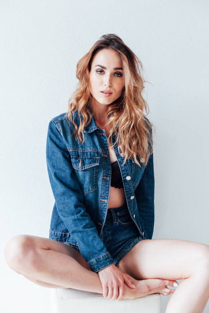 portrait of a beautiful fashionable woman in a denim jacket and shorts - Foto, imagen