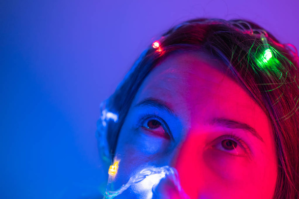 Portrait of a woman in neon lights. Concept of party, celebration, making a wish or new year evening party - Foto, Imagen