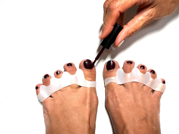 Il maestro fa pedicure sulle unghie dei piedi. Dispositivo dito in silicone
. - Foto, immagini