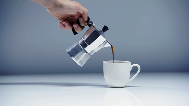 levágott kilátás az ember öntés espresso csészébe fehér és szürke  - Felvétel, videó
