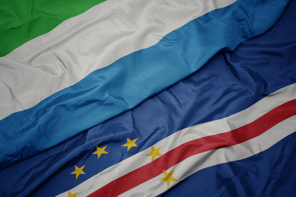 махаючи барвистим прапором мису Верде і національним прапором Сьєрра-Леоне
. - Фото, зображення