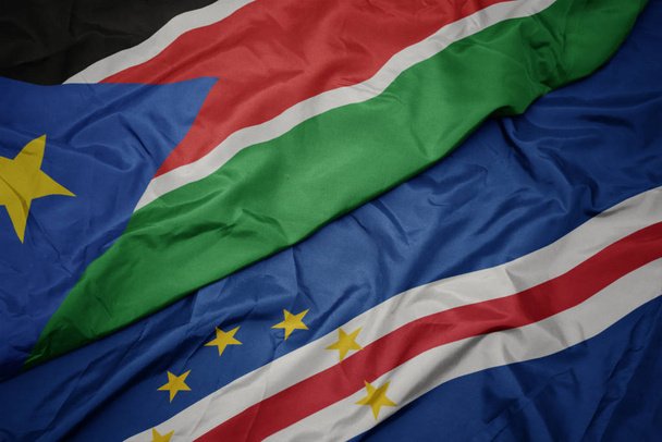 розмахуючи барвистим прапором плащаниці і національним прапором півдня Судану. - Фото, зображення