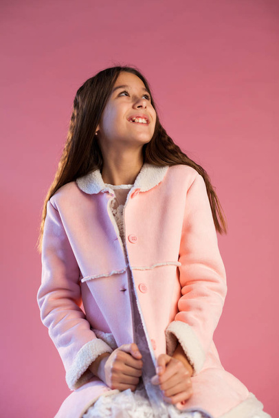 Portrait of a beautiful fashionable girl in a pink jacket and white dress - Foto, Bild