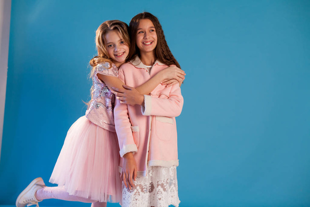 Портрет двох красивих модних дівчат у біло-рожевих сукнях
 - Фото, зображення