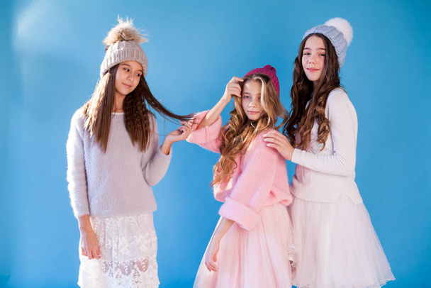 Three beautiful fashionable girlfriend girls in hats with snow in winter - Photo, Image