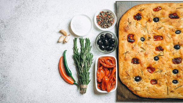 Tradycyjne włoskie Focaccia z pomidorami, oliwkami i rozmarynem - domowej roboty płaski chleb focaccia. - Zdjęcie, obraz