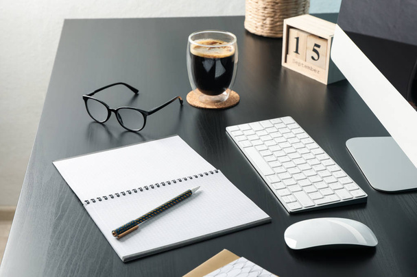 Lugar de trabajo con ordenador, vaso de café y cuaderno vacío en w
 - Foto, imagen