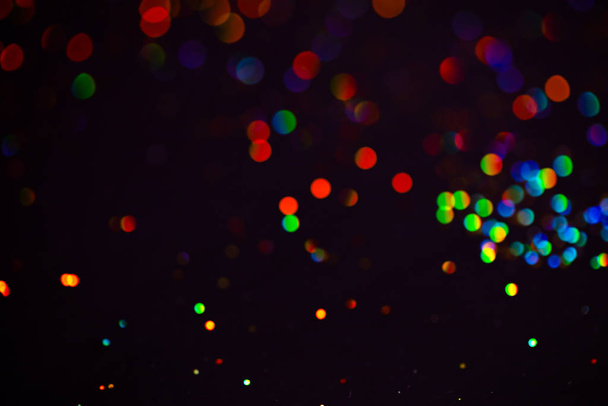Multicolor glitter raster background. Abstract shimmering red circles on deep purple backdrop. Vibrant bokeh lights effect festive illustration. Overlapping glowing and twinkling spots. - Photo, image