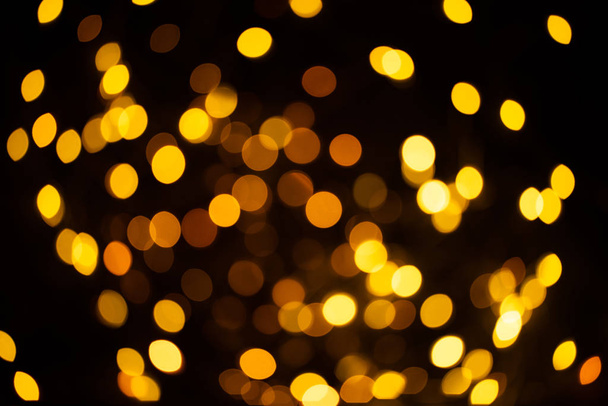 Bright golden glitter festive background. Abstract shimmering circles decorative backdrop. Bokeh lights with shiny effect. Overlapping glowing and twinkling spots - Photo, image